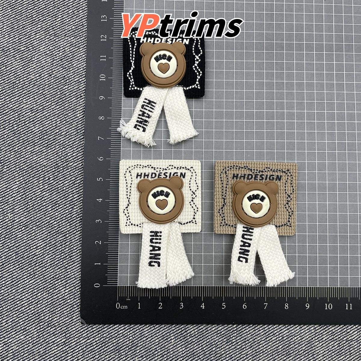 custom cartoon bear head 3d leather patch with flat cotton rope for kidswear supplier